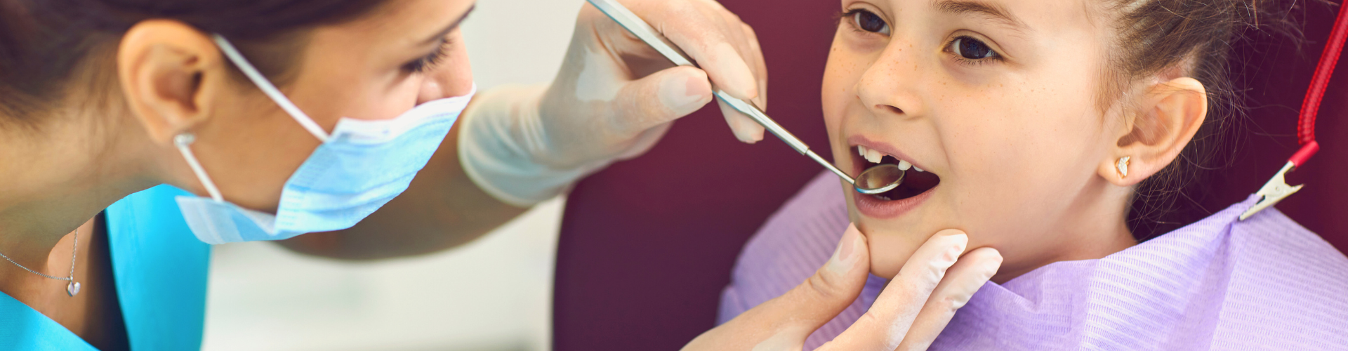 Dentist using dental tools in girl's mouth.